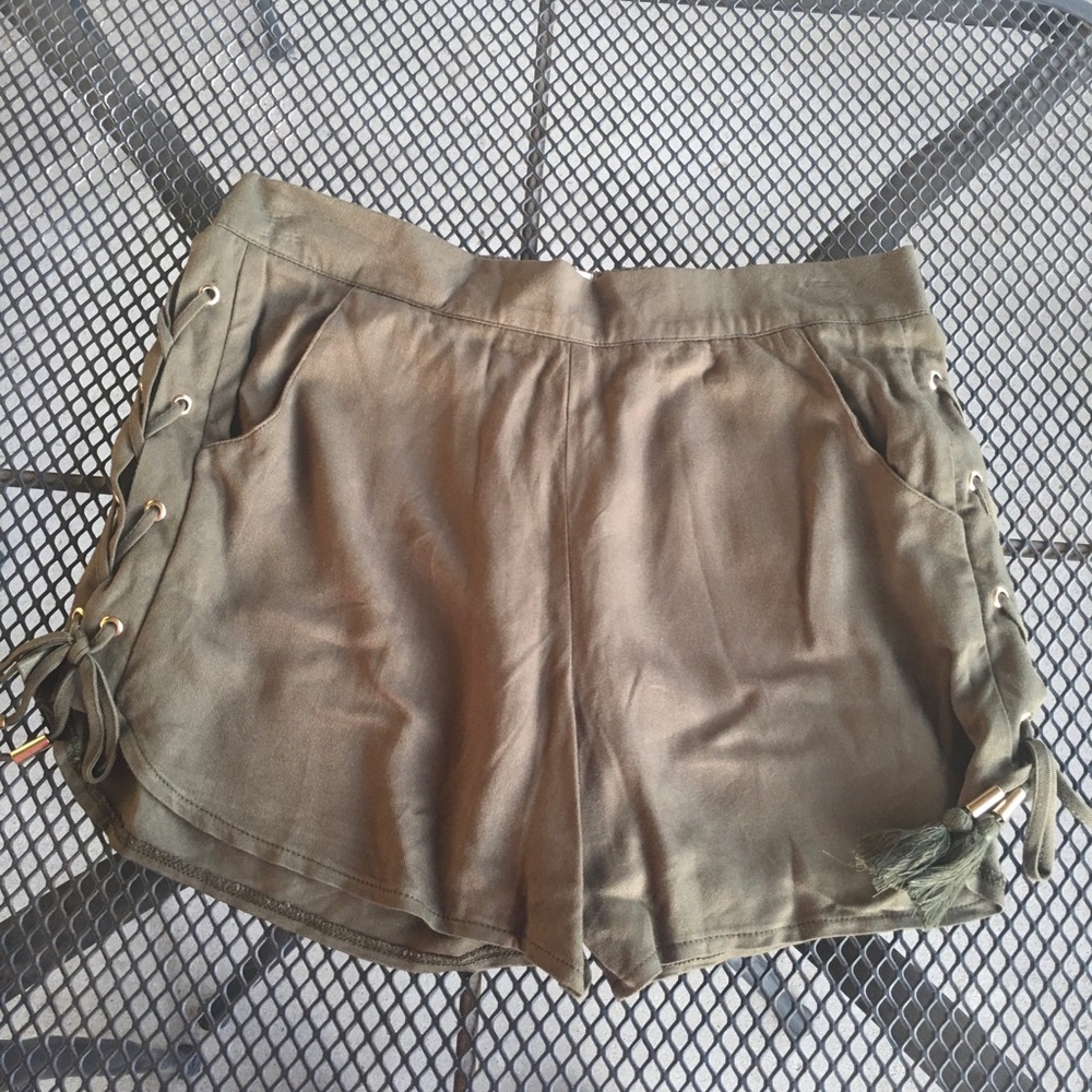 olive green shorts with gold accents and tassels
